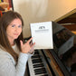 Aimee Nolte posing with custom music notebook, front